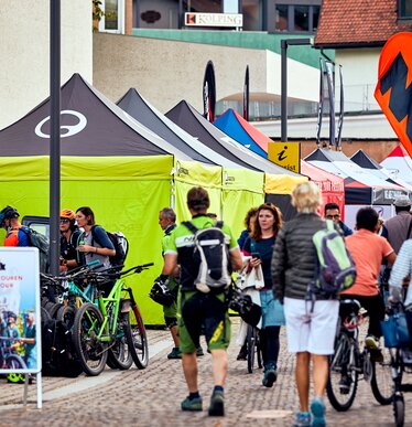 Row of 4x4 m black and lime tents with Ergon logo side walls at the Brixen Bike Festival