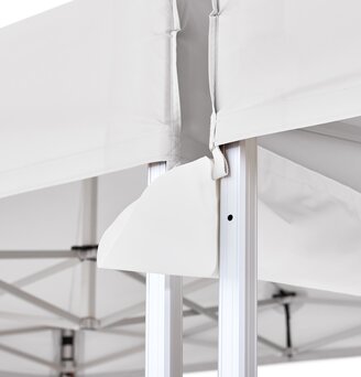 The rain gutter is mounted between two light grey folding gazebos.